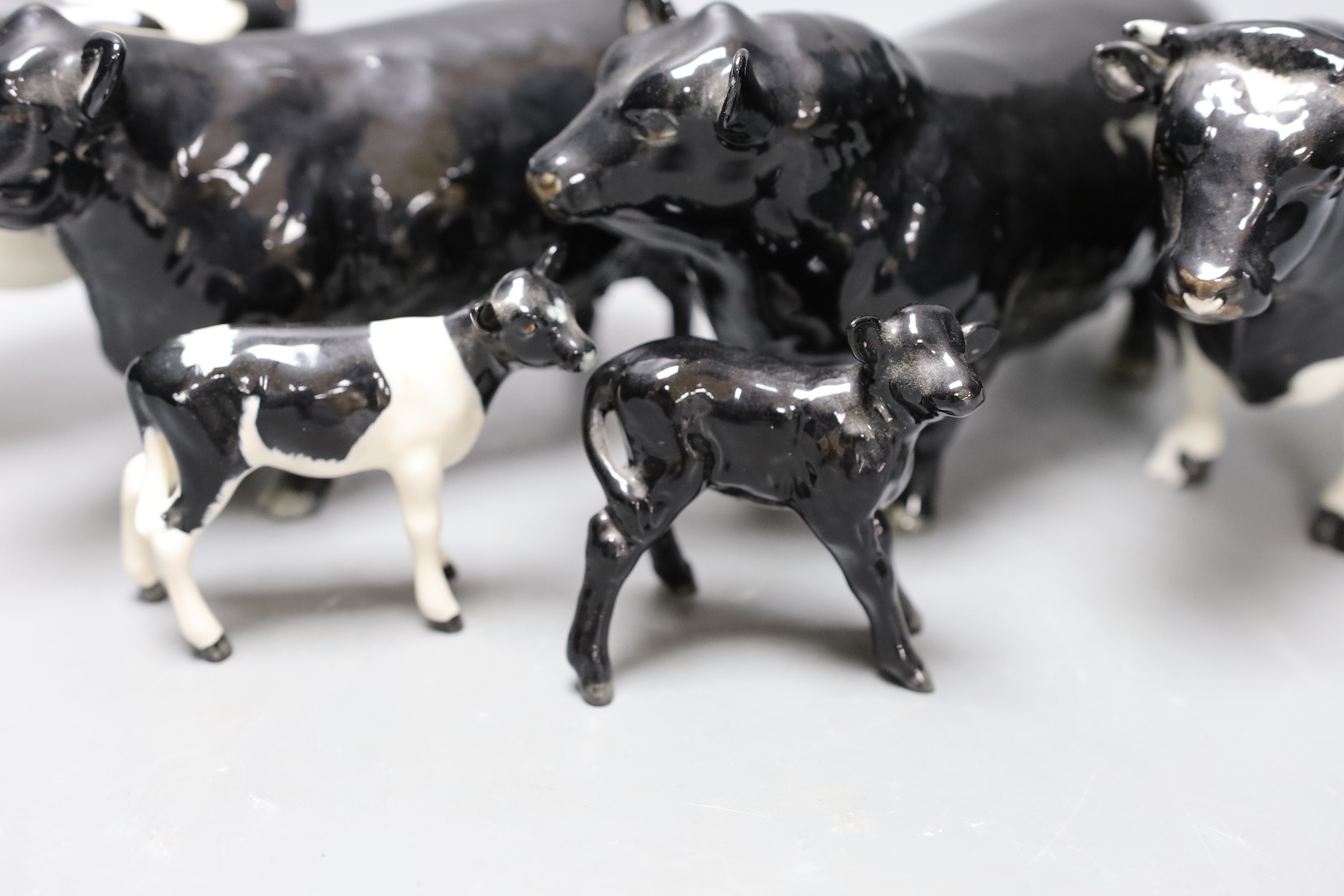A Beswick Aberdeen Angus bull, cow and calf, together with a Godington Hilt Bar bull, cow and calf